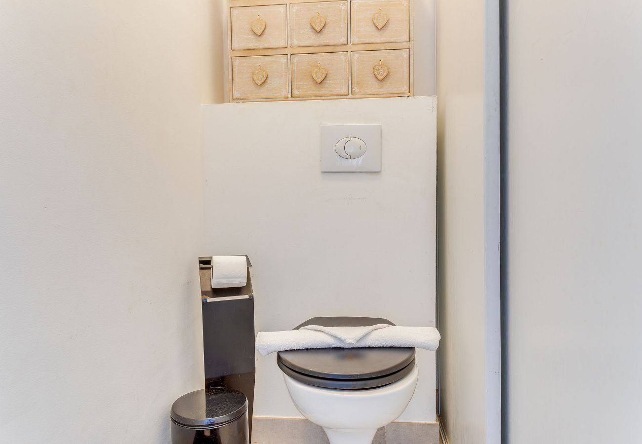 Compact separate toilet with folded towel and light decor