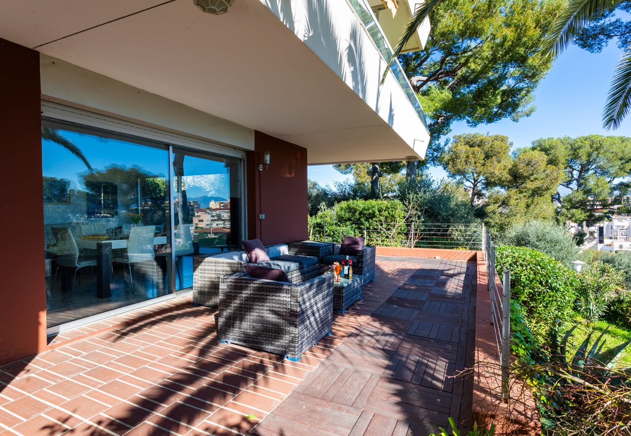 Terrasse confortable avec fauteuils et vue dégagée sur la verdure et la ville, idéale pour se détendre.