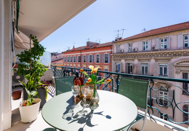 Balcon charmant avec vue sur les façades colorées, parfait pour un moment de détente en extérieur.