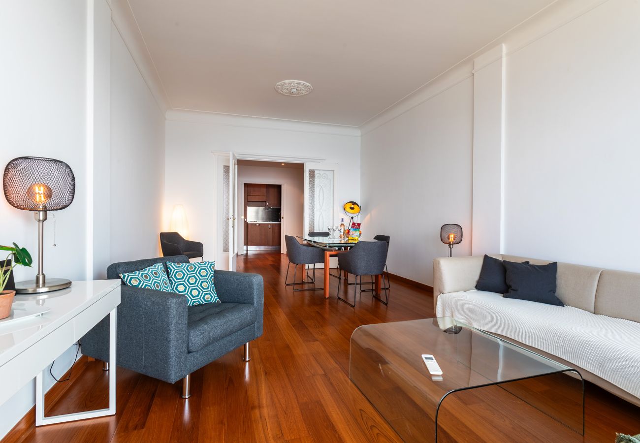 Salon moderne et coin repas lumineux avec parquet et ambiance chaleureuse pour un séjour agréable.