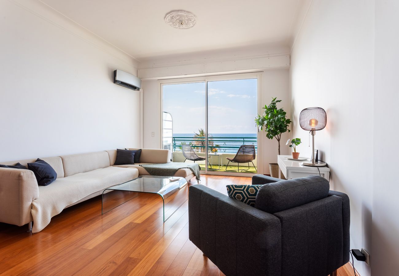 Salon moderne et lumineux avec balcon offrant une vue mer exceptionnelle, parfait pour la détente.