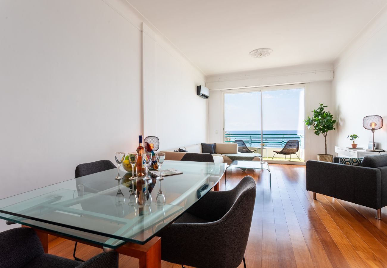  Vue mer depuis un salon élégant et lumineux avec espace repas moderne et ouvert. Ambiance chaleureuse et conviviale.