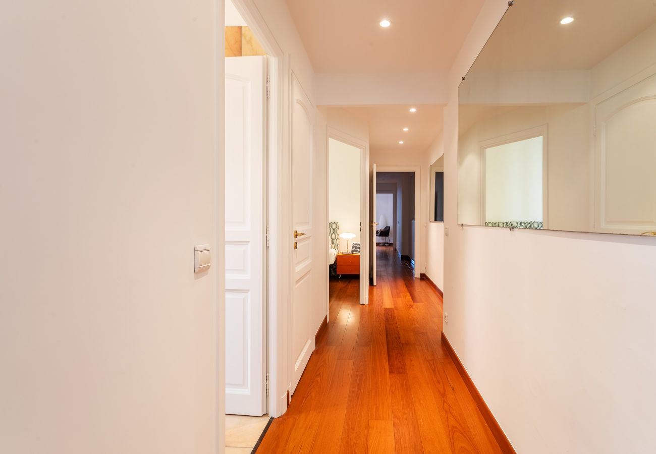 Couloir lumineux au parquet élégant, reliant les pièces avec fluidité pour un séjour confortable.
