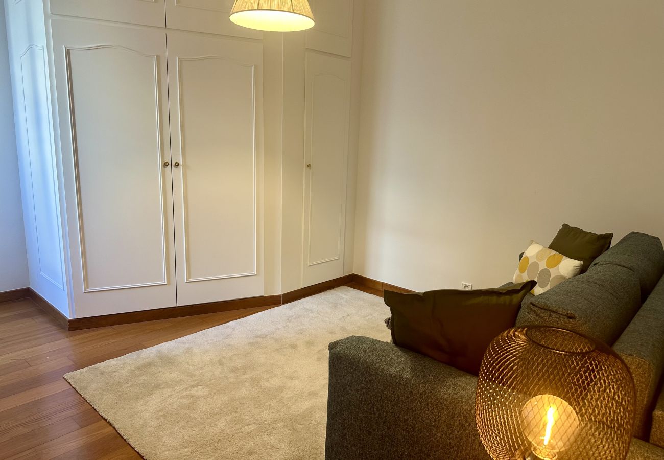 Espace lumineux avec canapé et rangements, idéal comme bureau ou salle de jeux pour des moments agréables.