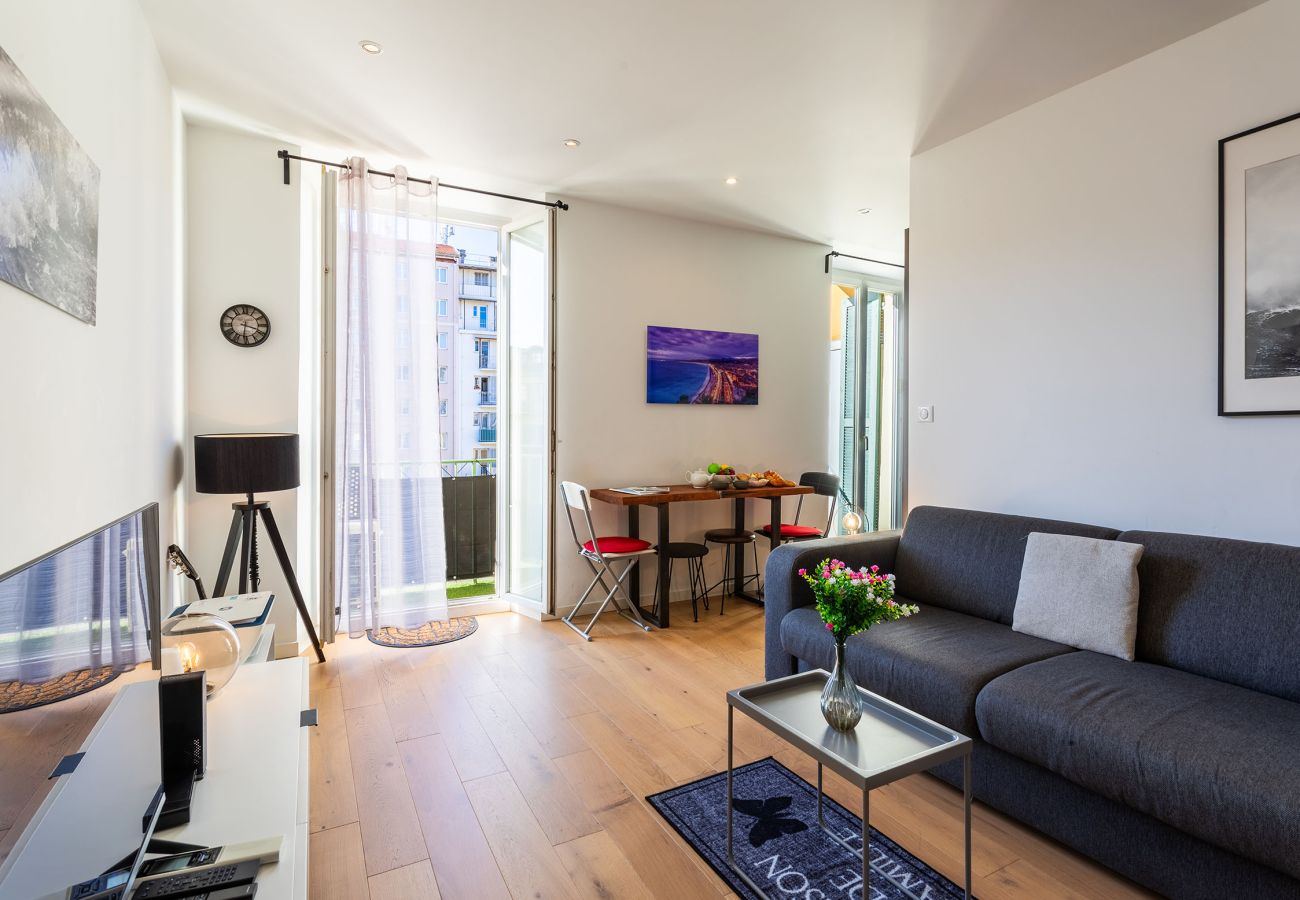  Salon élégant avec lumière naturelle, balcon, canapé confortable et espace repas convivial.